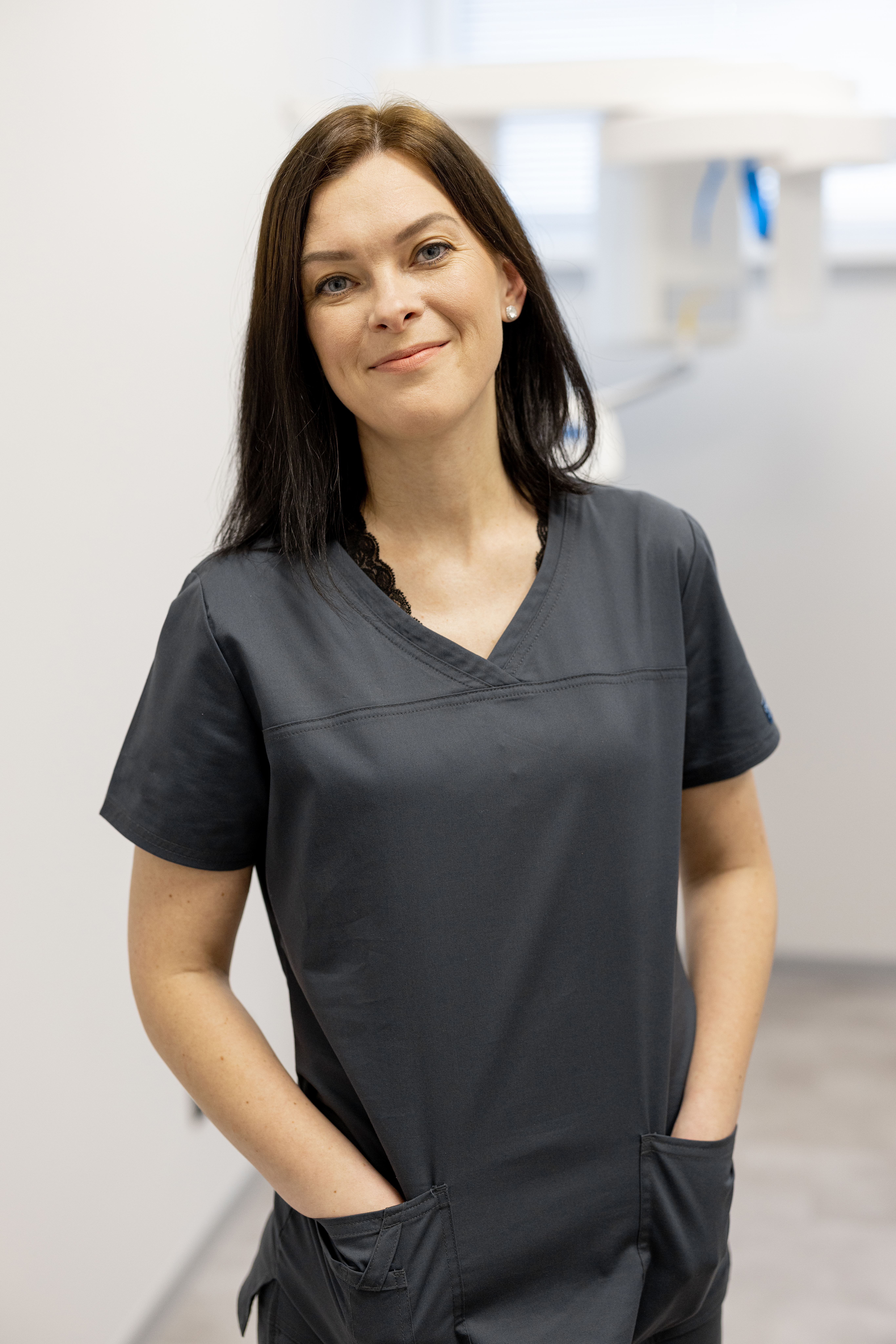 Portrait of a young cheerful doctor radiologist in x-ray room of the clinic