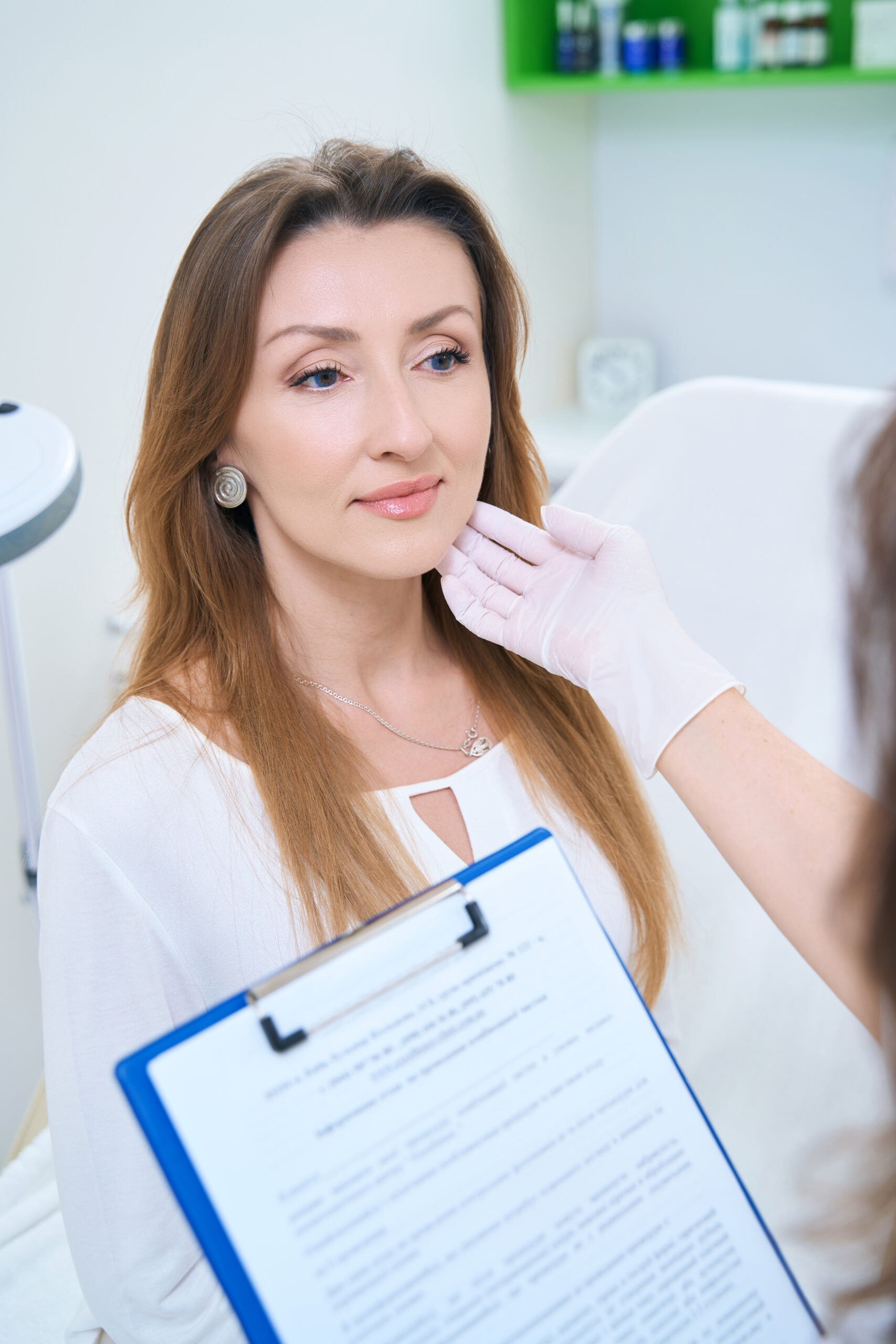 Doctor in gloves and with a medical card in his hands examines the patient face